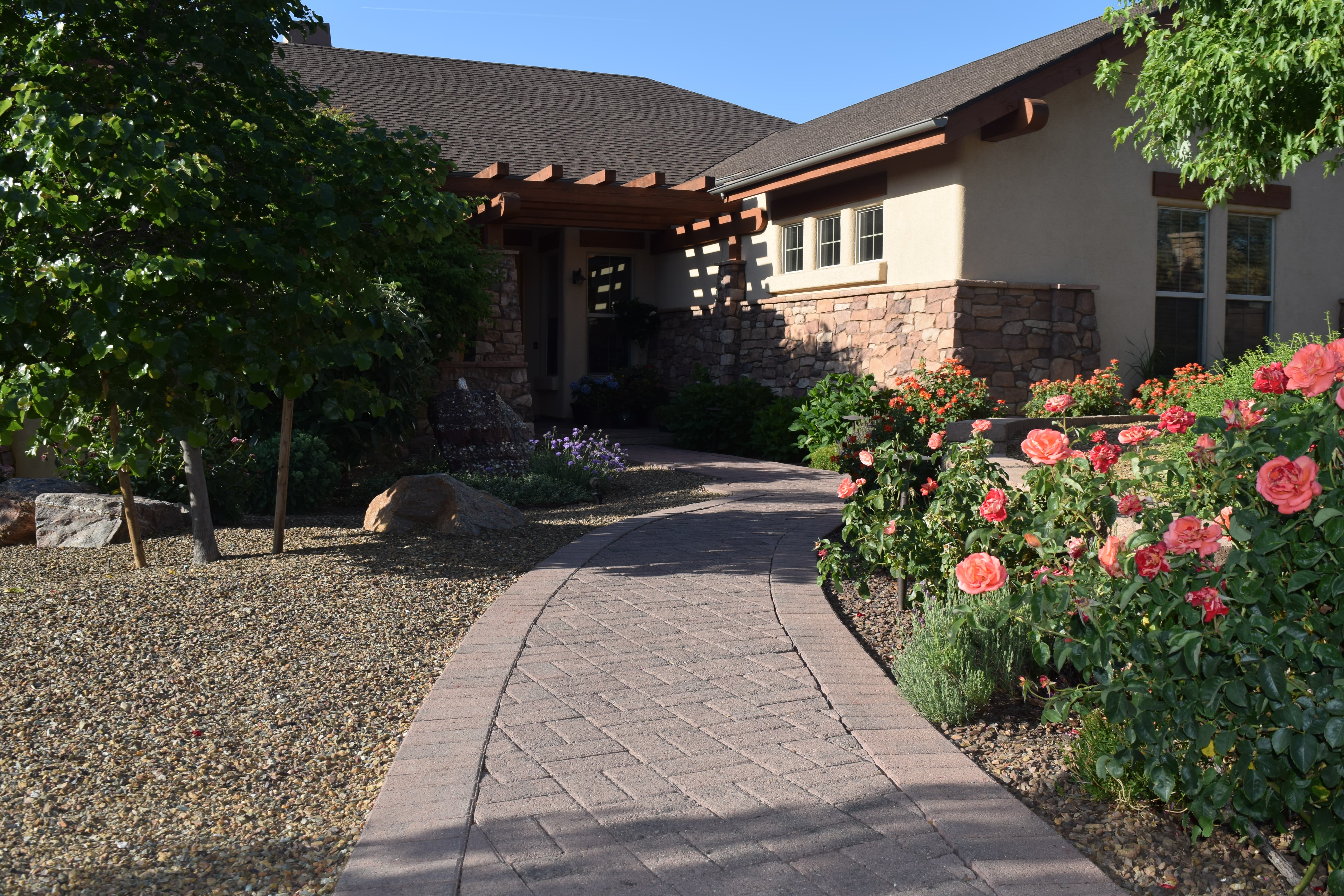 An image of a paved path leading to a house showing off the curb appeal of the home. Done by Vicente Landscaping in Northern Arizona