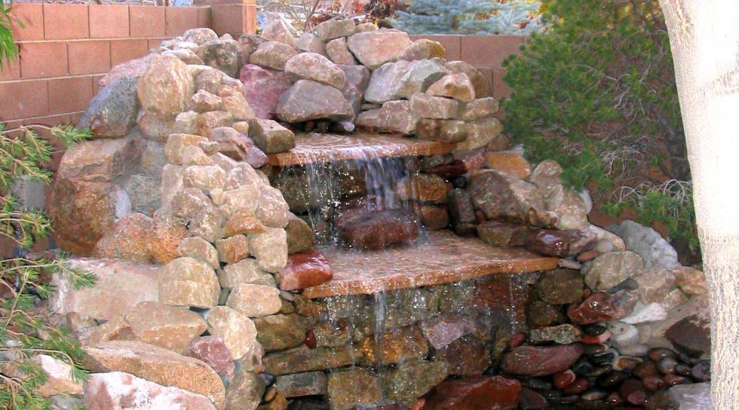 A brick water feature waterfall in a backyard