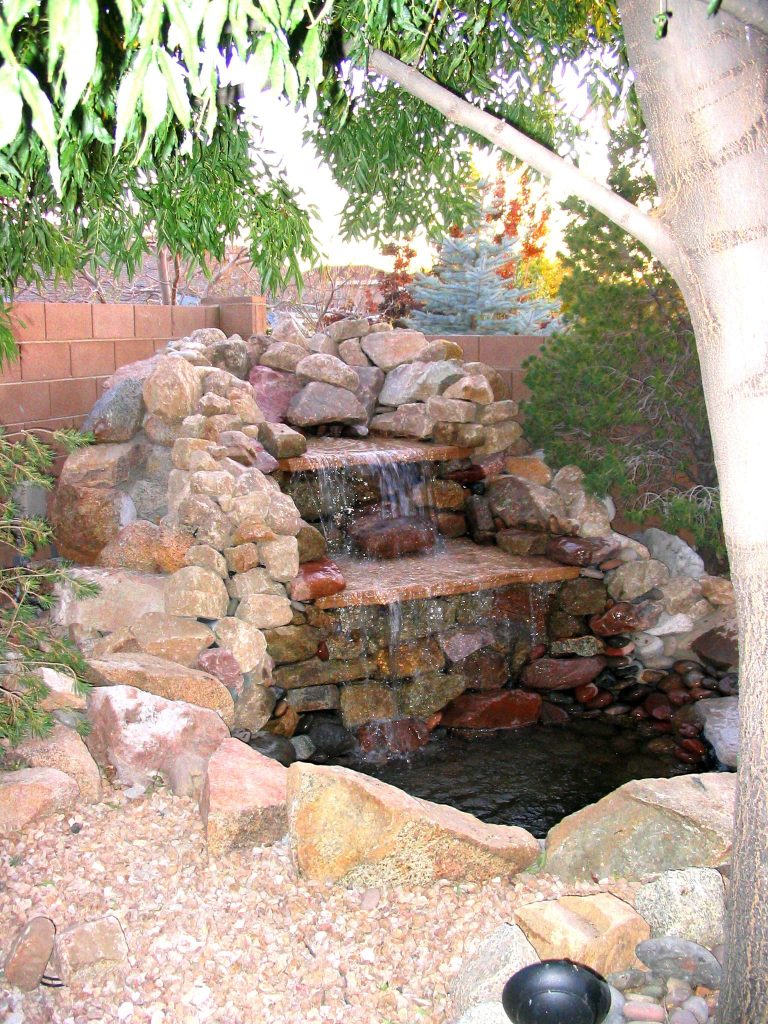 A brick water feature waterfall in a backyard