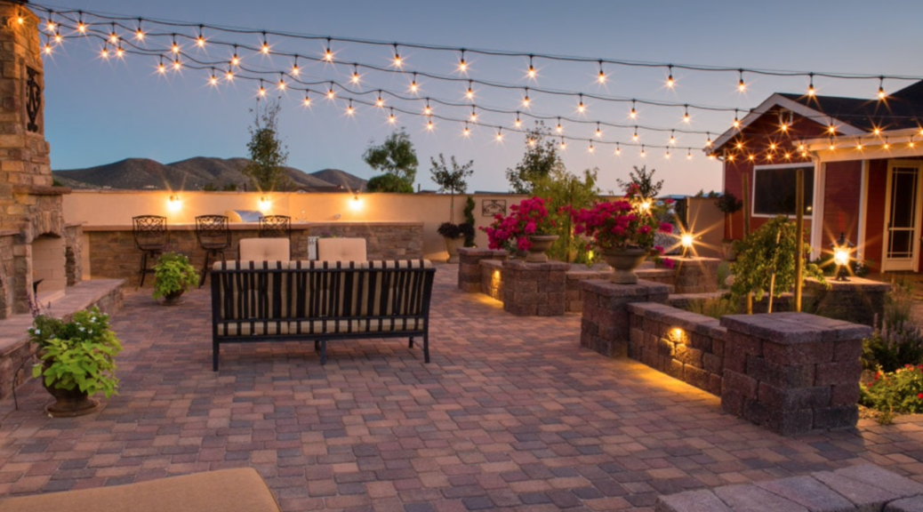 A remodeled backyard patio with stone flooring and outdoor furniture.